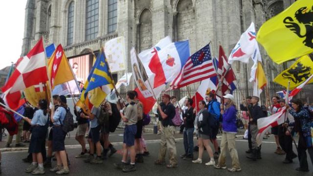 Jóvenes americanos y europeos con banderas del Corazón de Jesús. 