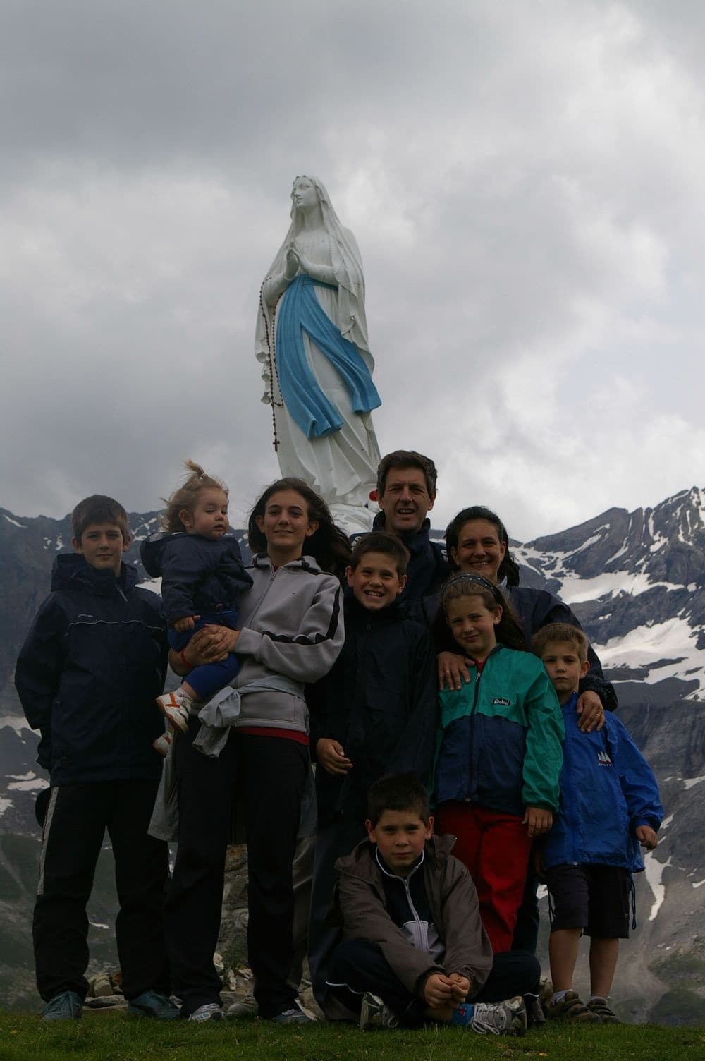 Familia Borsani, junto a una escultura de la Virgen en la montaña.