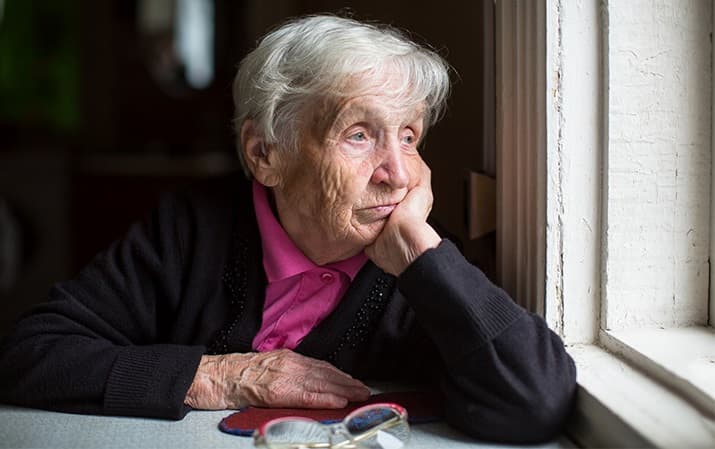 Una anciana mira por la ventana en pleno confinamiento