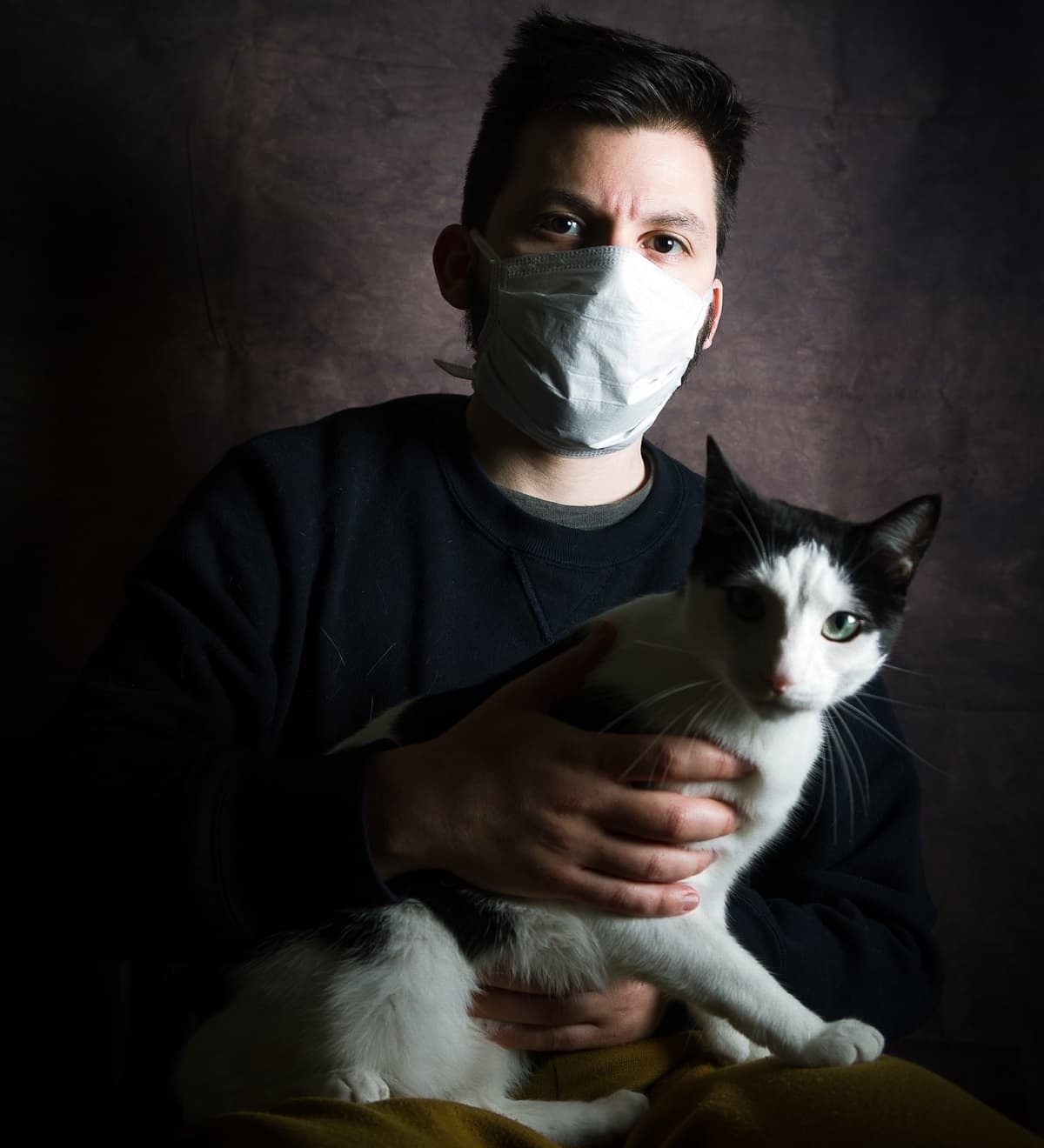 Un hombre con mascarilla y gato