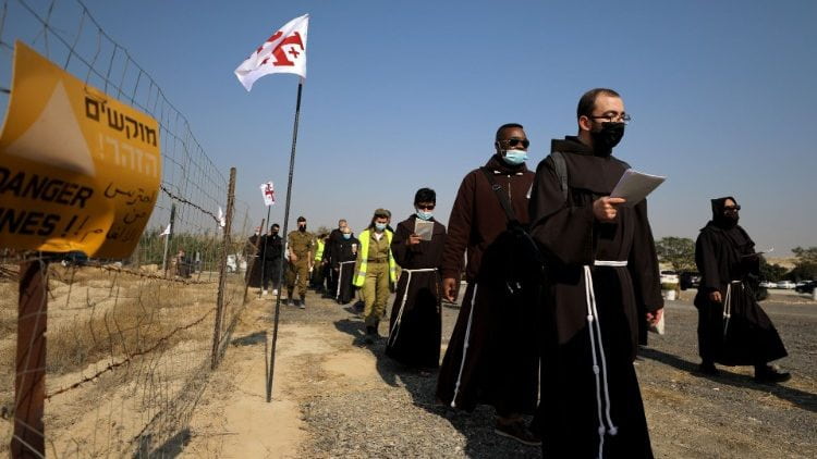 Procesión de los franciscanos junto a una zona del Jordán que aún ha de ser desminada