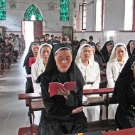 Un grupo de religiosas chinas ora en una iglesia.