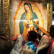 Unos fieles veneran la imagen de la Virgen de Guadalupe