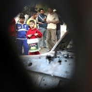 Un niño iraquí pasa junto a uno de los coches que ha explotado