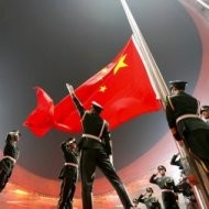 Soldados chinos izan y saludan a la bandera de su país
