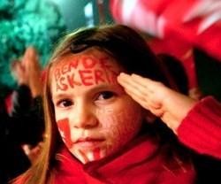 Una niña pintada con colores, banderas y lemas de la nación turca