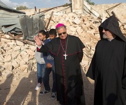 El patriarca católico Fouad Toual, con unos niños árabes y un clérigo armenio, junto a las ruinas de la casa derruida en terreno del Patriarcado