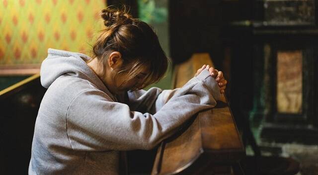 Una mujer centrada en oración en una iglesia, foto de Freepik