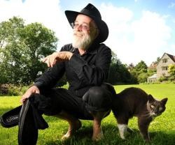 Terry Pratchett, con su inseparable sombrero negro y un gato a juego