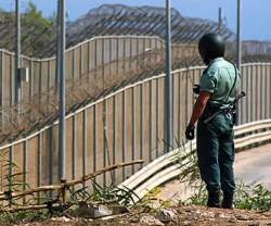 Un guardia civil ante la valla que separa Melilla de Marruecos, país confesionalmente islámico