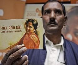 El marido de Asia Bibi con una postal que pide su liberación... ella lleva ya años en la cárcel en durísimas condiciones