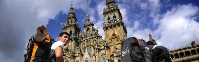 Un peregrino ante la catedral de Santiago de Compostela - el arte y las tradiciones católicas generan riqueza, cultura y empleo