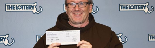 El padre Thomas Conway del santuario de San Antonio de Boston al cobrar el boleto de lotería