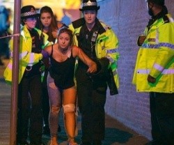 Una chica lesionada en el Manchester Arena, acompañada por policías británicas