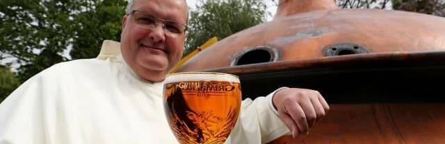 Un monje belga muestra una de las cervezas que produce su abadía