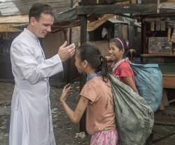 El misionero Matthieu Dauchez con niñas basureras de Manila - allí hay dolor, y también alegría