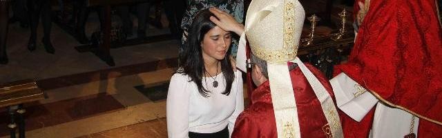 Una joven recibe el sacramento de la confirmación... hubo 116.000 en 2014 en España