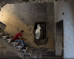 Estudiante cristiano rezando el Rosario en un edificio destruído por la guerra en Siria. Foto (C) Ismael Martínez Sánchez/ACN