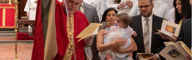 Una familia joven bautizando a su hija. 