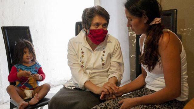 La hermana Mercedes Castillo escucha a una migrante hondureña.