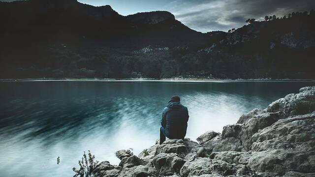 Un hombre solo ante un lago.