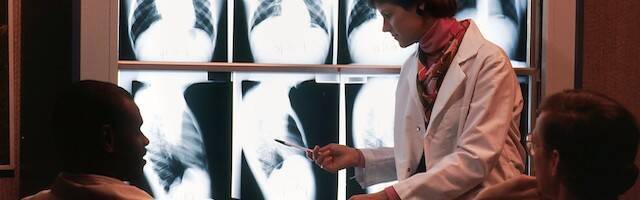 Tres médicos examinan unas radiografías.