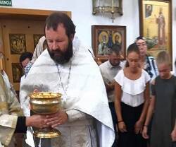 El padre Kordochkin con feligreses de la basílica ortodoxa de Madrid en la fiesta de San Salvador de las Manzanas, que bendice fruta en agosto, en 2019