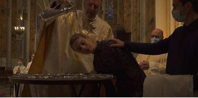 Un obispo bautiza una chica francesa en la catedral