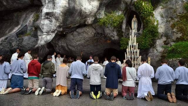 Peregrinos ante la Virgen de Lourdes.