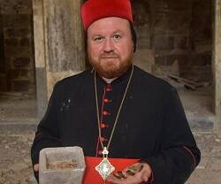 Sharaf, obispo siro-ortodoxo de Mosul, muestra los recipientes de piedra y las reliquias guardadas dentro en la destrozada iglesia de Santo Tomás