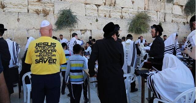 El hombre de la camiseta amarilla lleva un mensaje cristiano, Jesús como puerta a la salvación, en el Muro de las Lamentaciones de Jerusalén
