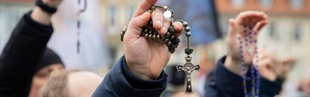 Hombres rezando el rosario. 