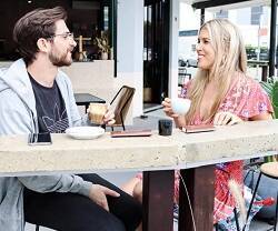 Un joven y una joven toman café y charlan - SocialCut en Unsplash