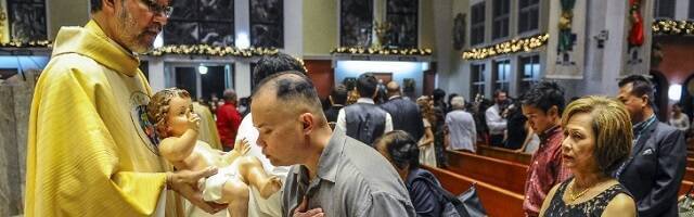 Adoración al Niño en Agaña, Guam, en 2014... incluso un no bautizado puede besar  la imagen del Niño