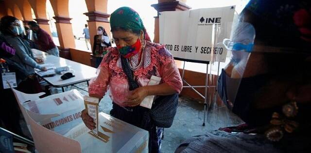 Una mujer introduce su voto en urna en las elecciones mexicanas de 2021