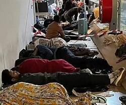 Migrantes durmiendo en el suelo en la zona internacional del aeropuerto de Barajas en febrero