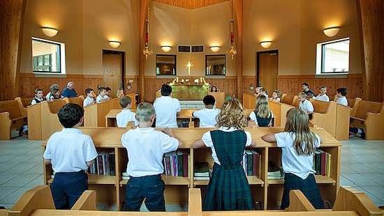 Niños y adolescentes rezando en la iglesia.