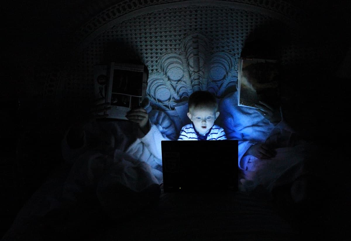 Niño fascinado por la pantalla de un portátil, padres despistados - foto de Ludovic Toinel para Unsplash