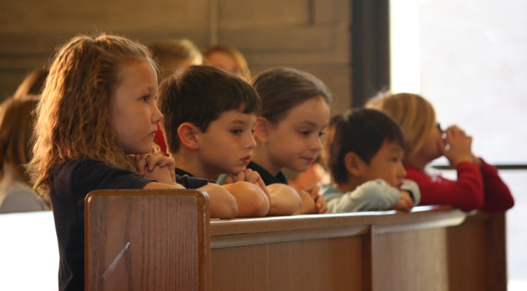 Niños en misa arrodillados