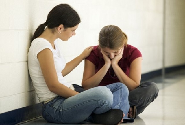 Dos chicas sentadas comparten preocupaciones.