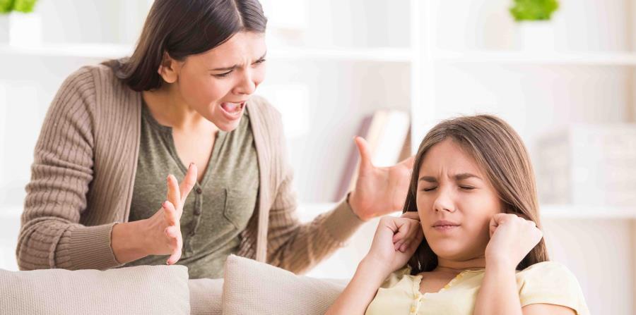 Una madre grita a su hija adolescente que se tapa los oídos