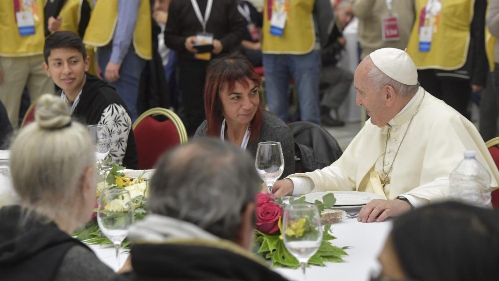 El Papa sentado a la mesa y rodeado de pobres, durante la celebración de 2019