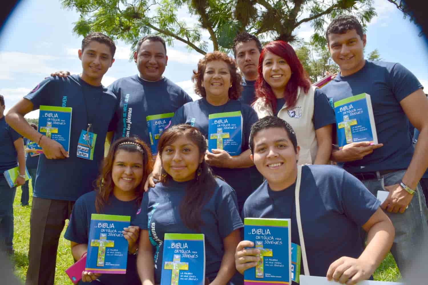 Jóvenes sonrientes con una Biblia católica para jóvenes