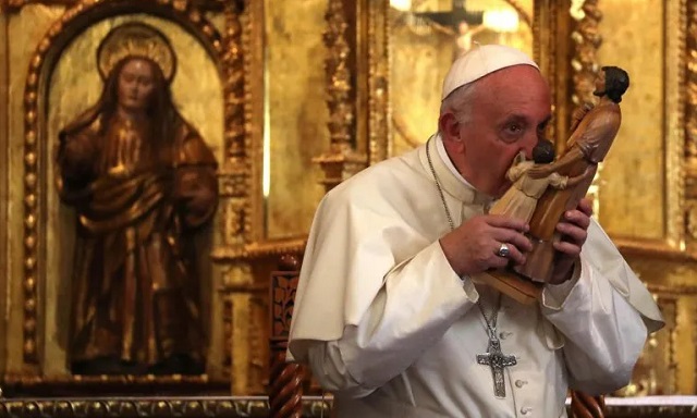 El Papa Francisco besa una imagen de San José  y el Niño