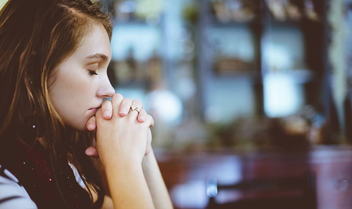 Una chica rezando.