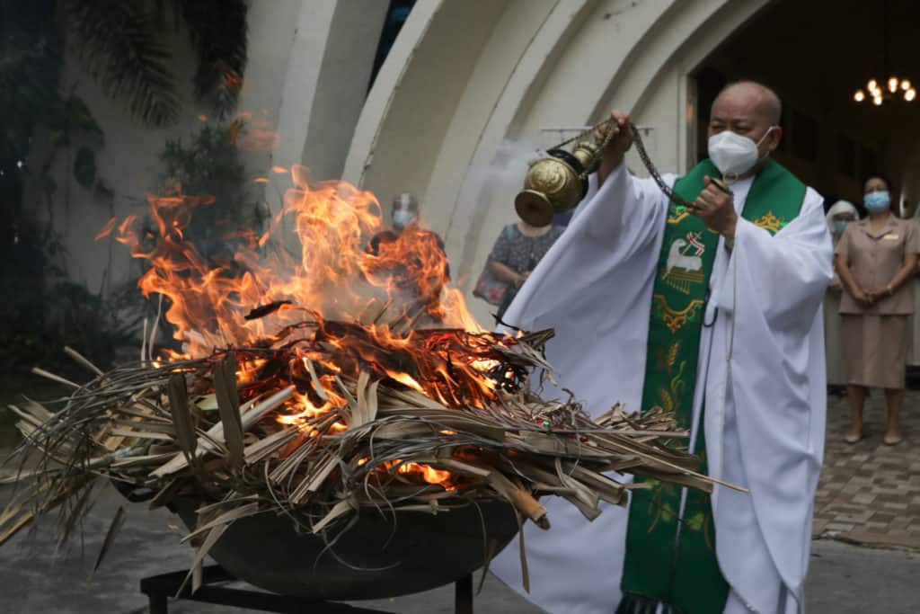 Un sacerdote quema las palmas de Domingo de Ramos para  preparar las cenizas del Miércoles de Ceniza -- foto de Jansen Romero, Manila Bulletin