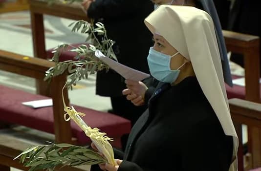 Monja con ramos y mascarilla en la misa del Papa de Domingo de Ramos 2021 en el Vaticano