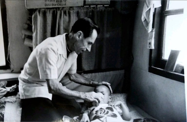Aloysius Schwartz dando de comer a un niño enfermo en uno de sus hospicios