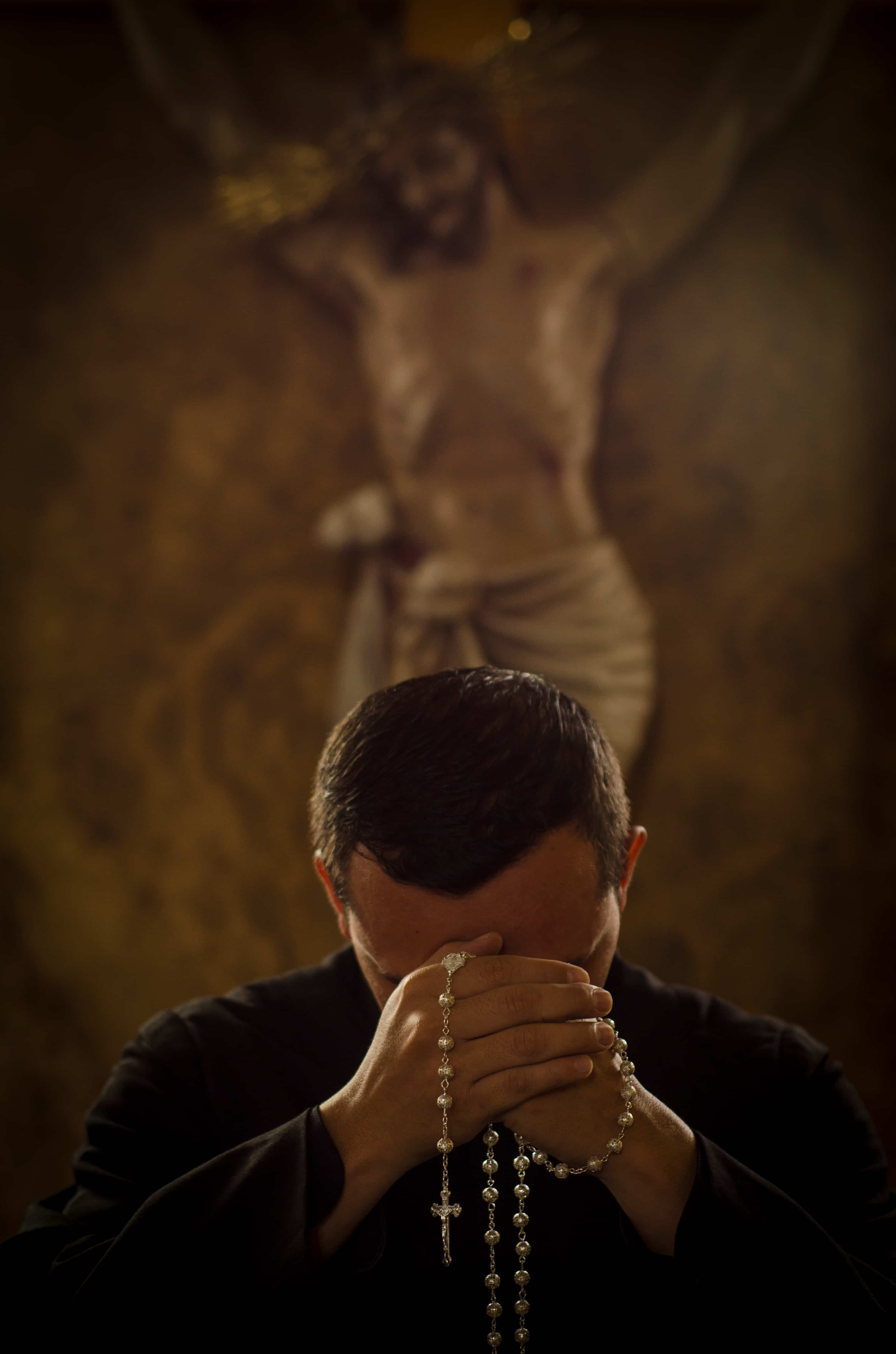 Hombre rezando de rodillas. 