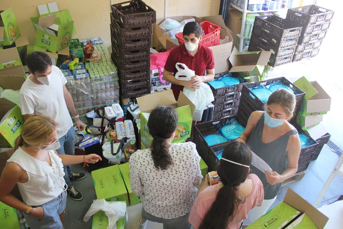 Voluntarios de RedMadre preparan paquetes de ayuda material, con mascarilla por el coronavirus